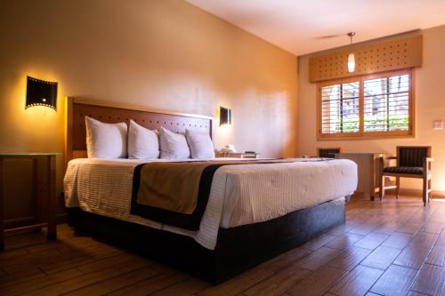 a bedroom with a large bed and a window at Hotel Colonial Mexicali in Mexicali