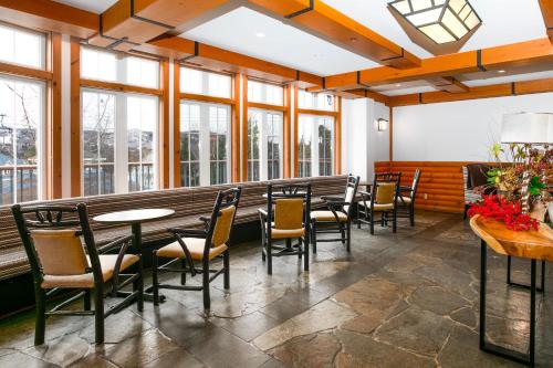 a dining room with tables and chairs and windows at Lodge de la Montagne in Mont-Tremblant