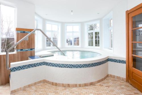 a large bathroom with a tub with windows at Lodge de la Montagne in Mont-Tremblant