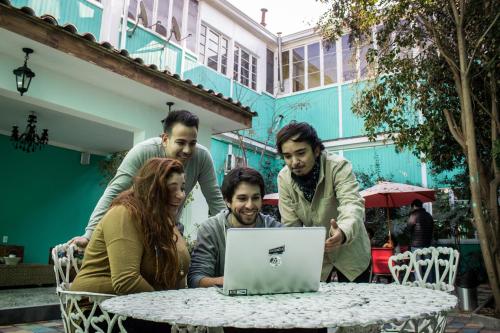 a group of people sitting around a table with a laptop at Hostal Providencia in Santiago