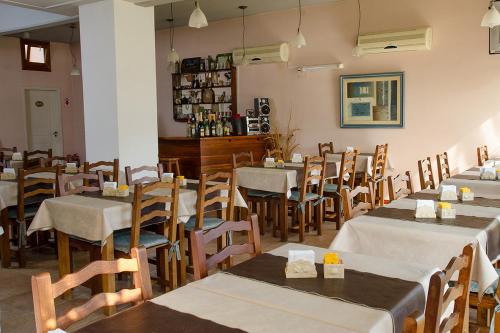 a restaurant with tables and chairs and a bar at Hosteria Kaiken II in Villa Gesell