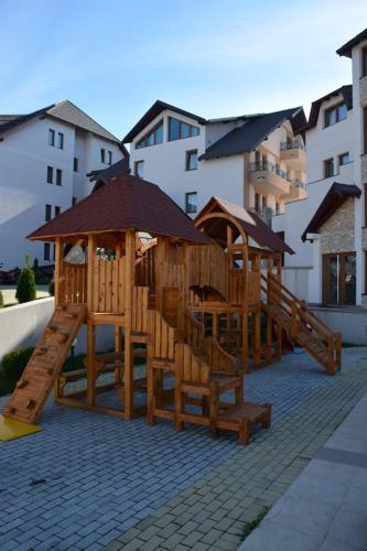 a set of wooden play structures on a patio at Apartman Sladjana Premier 12 Milmari in Kopaonik