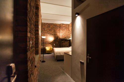 Pokój z sypialnią z łóżkiem i ceglaną ścianą w obiekcie Stawowa 13 w mieście Katowice