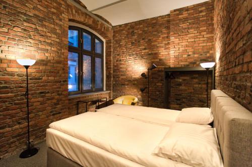 sypialnia z 2 łóżkami i ceglaną ścianą w obiekcie Stawowa 13 w mieście Katowice