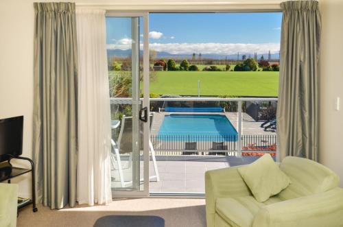 a living room with a view of a pool at Parkside Motel in Richmond