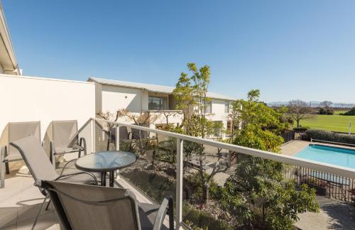 a balcony with a table and chairs and a pool at Parkside Motel in Richmond