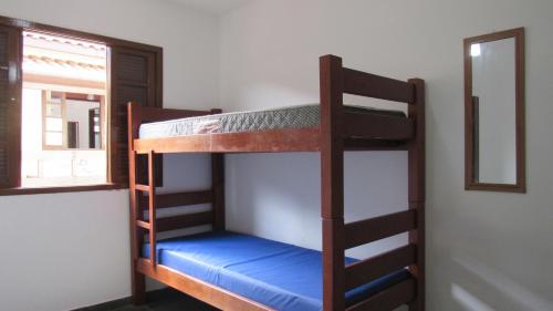 two bunk beds in a room with a window at Residencial Chalés Âncora in Ubatuba