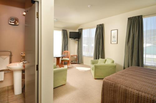 a hotel room with a bed and a sink at Parkside Motel in Richmond