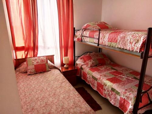 1 Schlafzimmer mit 2 Etagenbetten und einem Fenster in der Unterkunft Peñuelas excelente vista y ubicacion in Coquimbo
