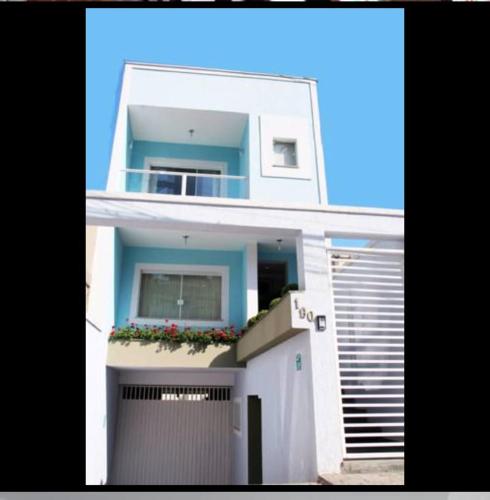 a large white house with a balcony and a garage at SETTA'S HOSTEL in Sao Paulo