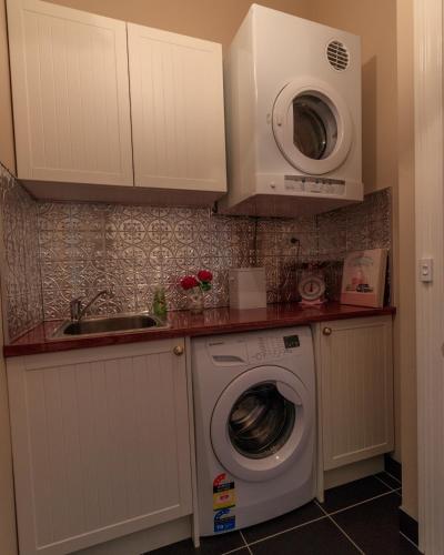 a kitchen with a washing machine and a microwave at The Oaks Lilydale Accommodation in Lilydale