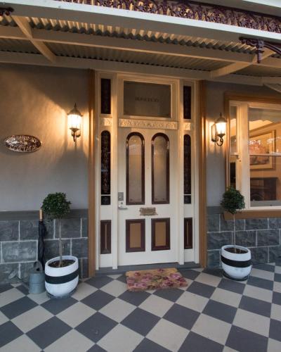 a front door of a house with a checkered floor at The Oaks Lilydale Accommodation in Lilydale