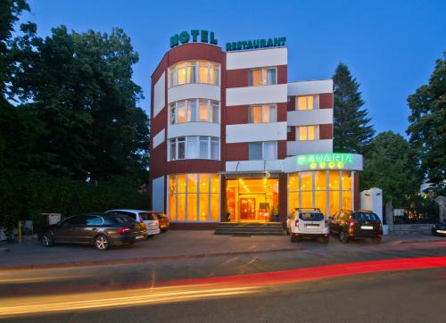 un edificio con coches estacionados frente a él en Hotel Bavaria, en Craiova