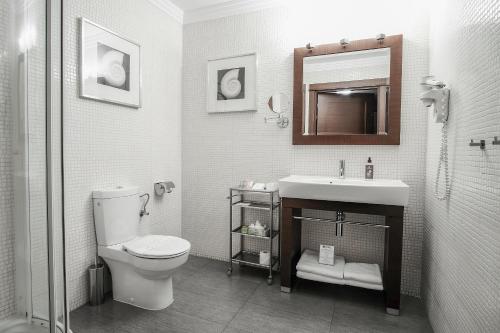 a bathroom with a toilet and a sink and a mirror at Vanilla Hotel in Lublin