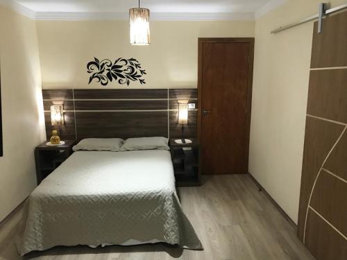 a bedroom with a bed with a wooden headboard at GA1-Hospedagem Próximo ao Aeroporto de Guarulhos in Guarulhos