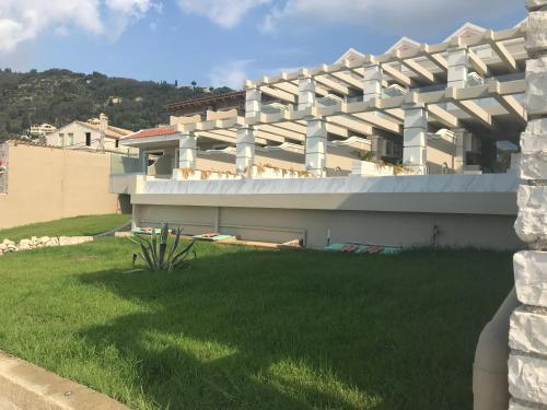 a building with a green lawn in front of it at Agios Gordios Beach Resort in Agios Gordios