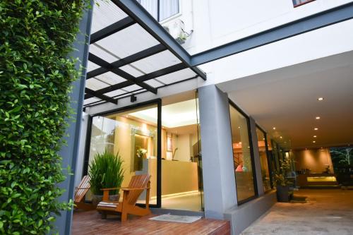 a glass extension to a building with a bench on a patio at B Boutique Residence in Suratthani