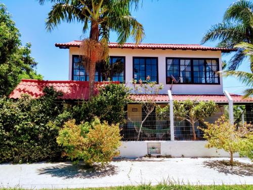 a house on the beach with a palm tree at The Cats' House in Florianópolis