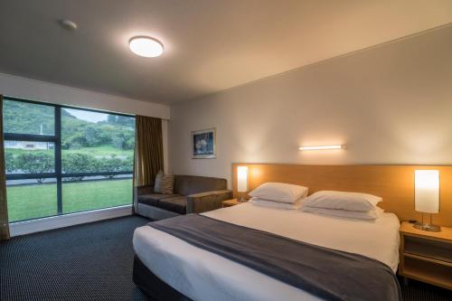 a hotel room with a bed and a large window at The Ashley Hotel Greymouth in Greymouth