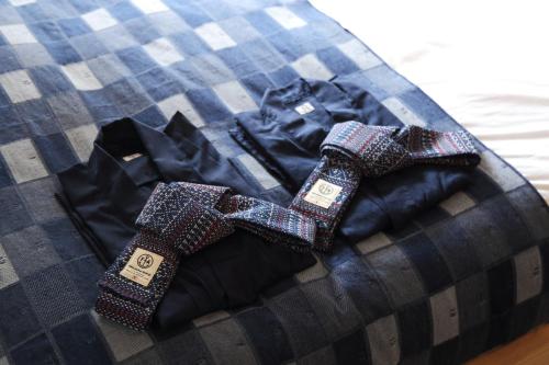 two ties sitting on top of a bed at Anchor Hotel Fukuyama in Fukuyama