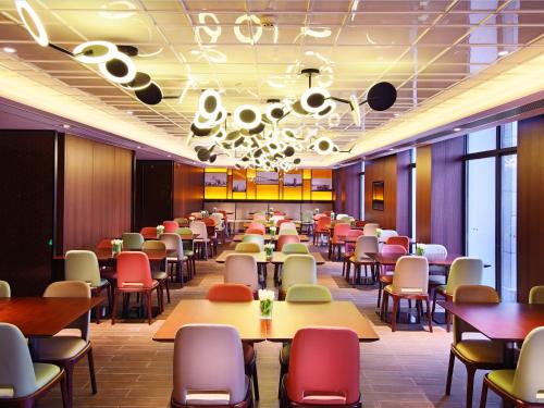 uma sala de jantar com mesas e cadeiras em Hampton by Hilton Zhuhai Cheng Feng Plaza em Zhuhai