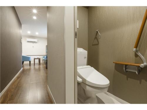 a bathroom with a toilet and a dining room at Kyo no yado en in Kyoto
