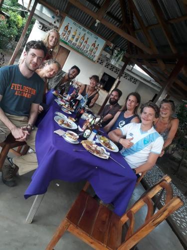 a group of people sitting around a table with food at Hostal La Cascada San Ramón in Mérida