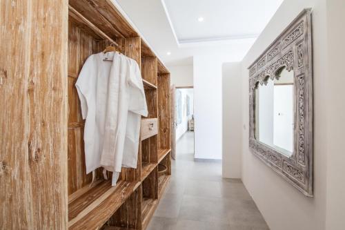 un couloir avec un miroir et un mur en bois dans l'établissement Ambermoon Villas, à Seminyak
