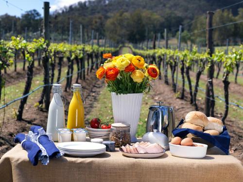 una mesa en un viñedo con un jarrón de flores en Winmark Wines, en Broke