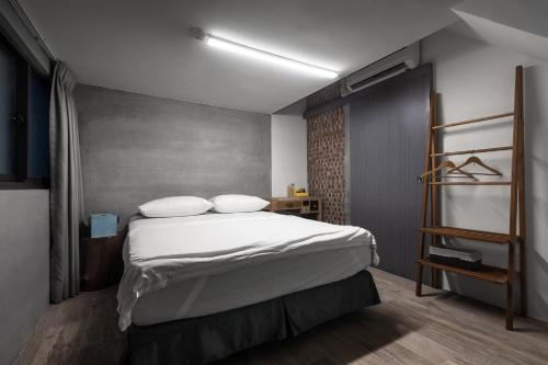 台南的住宿－愛藝宿Art Space，一间卧室配有带白色床单和枕头的床。