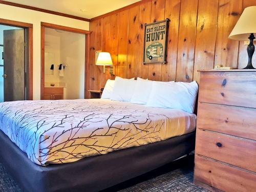 a bedroom with a bed with a wooden wall at Park Motel and Cabins in Florence