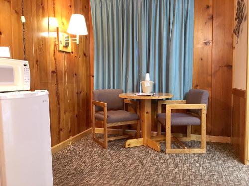 a room with a table and two chairs and a microwave at Park Motel and Cabins in Florence