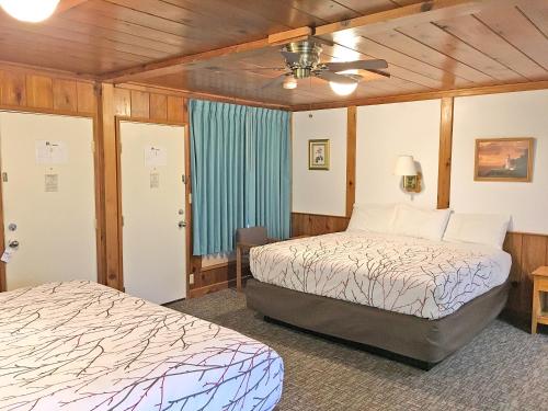a bedroom with two beds and a ceiling fan at Park Motel and Cabins in Florence
