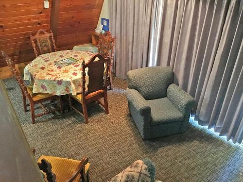 a living room with a table and a chair and a table and a chair at Park Motel and Cabins in Florence