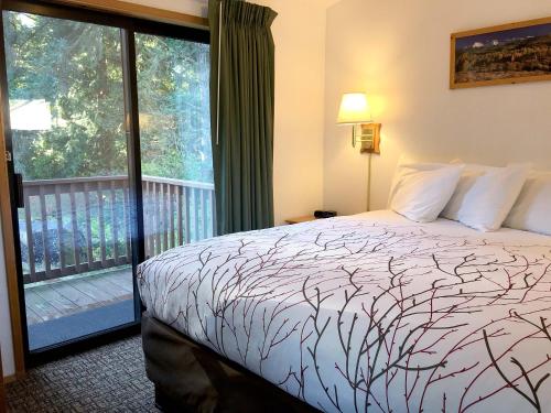 a bedroom with a bed and a balcony at Park Motel and Cabins in Florence
