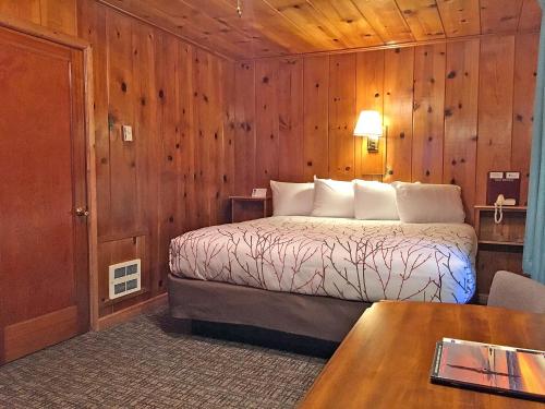a bedroom with a bed and a wooden wall at Park Motel and Cabins in Florence