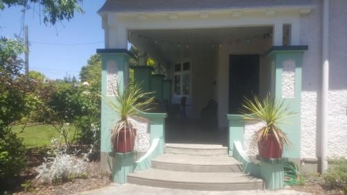 a house with two potted plants on the front porch at History @ Renall in Masterton