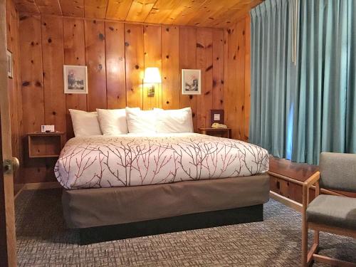 a bedroom with a bed in a wooden wall at Park Motel and Cabins in Florence