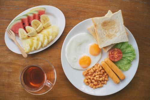 twee borden ontbijtproducten op een houten tafel bij Silver Beach Resort in Lamai