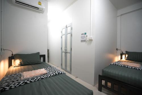 a bedroom with two beds and a window at Dhub Hostel Donmueng in Bangkok