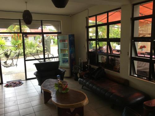 a living room with a couch and a table and windows at Bluewater Lodge in Nadi