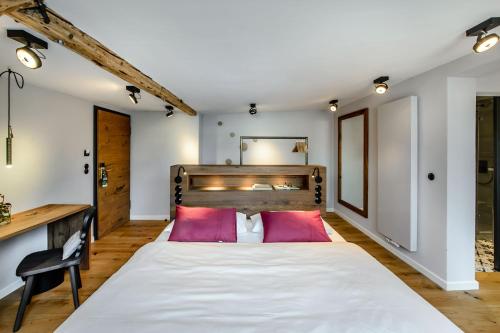 um quarto com uma grande cama branca com almofadas vermelhas em BIO-Hotel Adler/Restaurant em Vogt