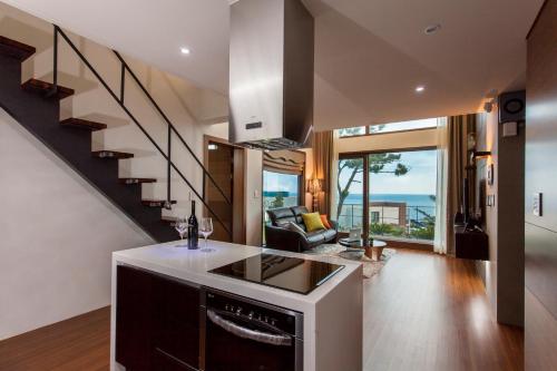 a kitchen with a staircase and a living room at Sun Village in Seogwipo