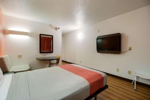 a room with a bed and a flat screen tv at Motel 6-Davenport, IA in Davenport