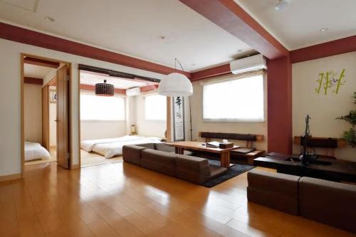 uma sala de estar com um sofá e uma mesa em TE Osaka Luxury Room em Osaka