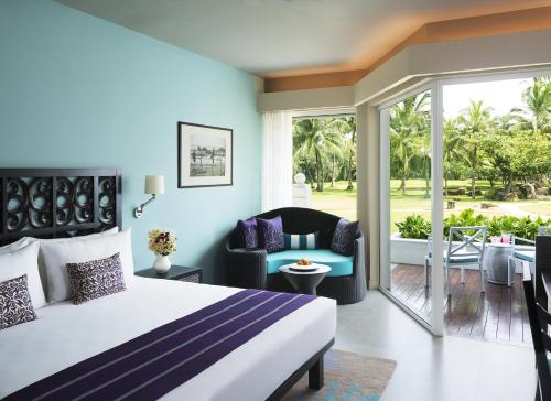 a hotel room with a bed and a balcony at Taj Bentota Resort & Spa in Bentota