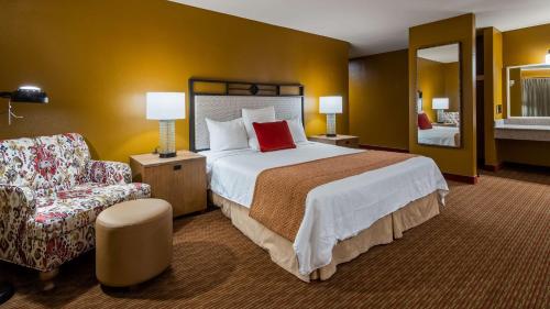 um quarto de hotel com uma cama grande e uma cadeira em SureStay Hotel by Best Western Camarillo em Camarillo