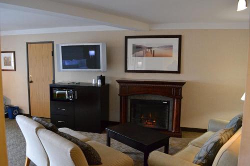 a living room with a fireplace and a tv at Best Western Plus Silverdale Beach Hotel in Silverdale