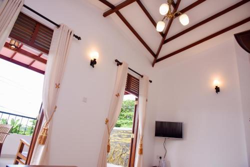 ベントータにあるMovi Holiday Apartmentの白い壁の客室で、テレビと窓が備わります。