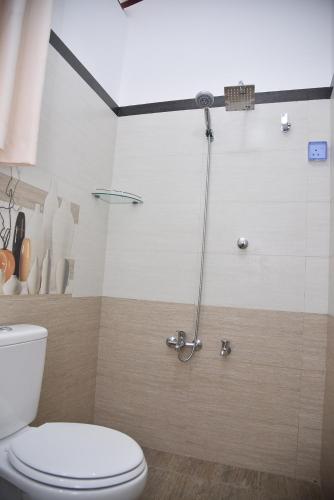 a bathroom with a toilet and a shower stall at Movi Holiday Apartment in Bentota
